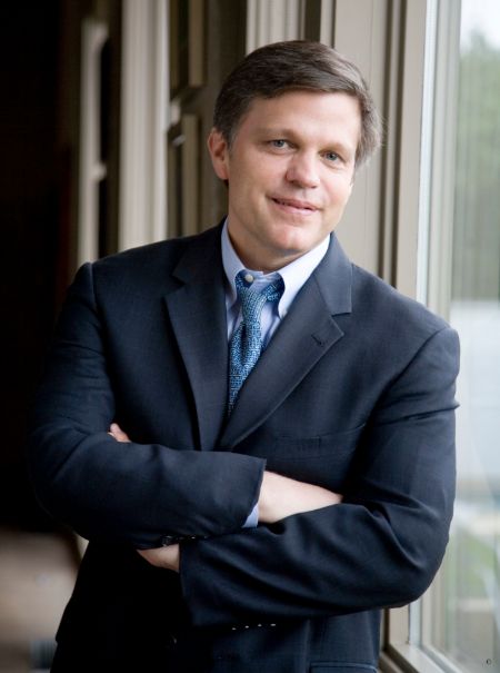 Douglas Brinkley in a black suit and blue tie poses for a picture.